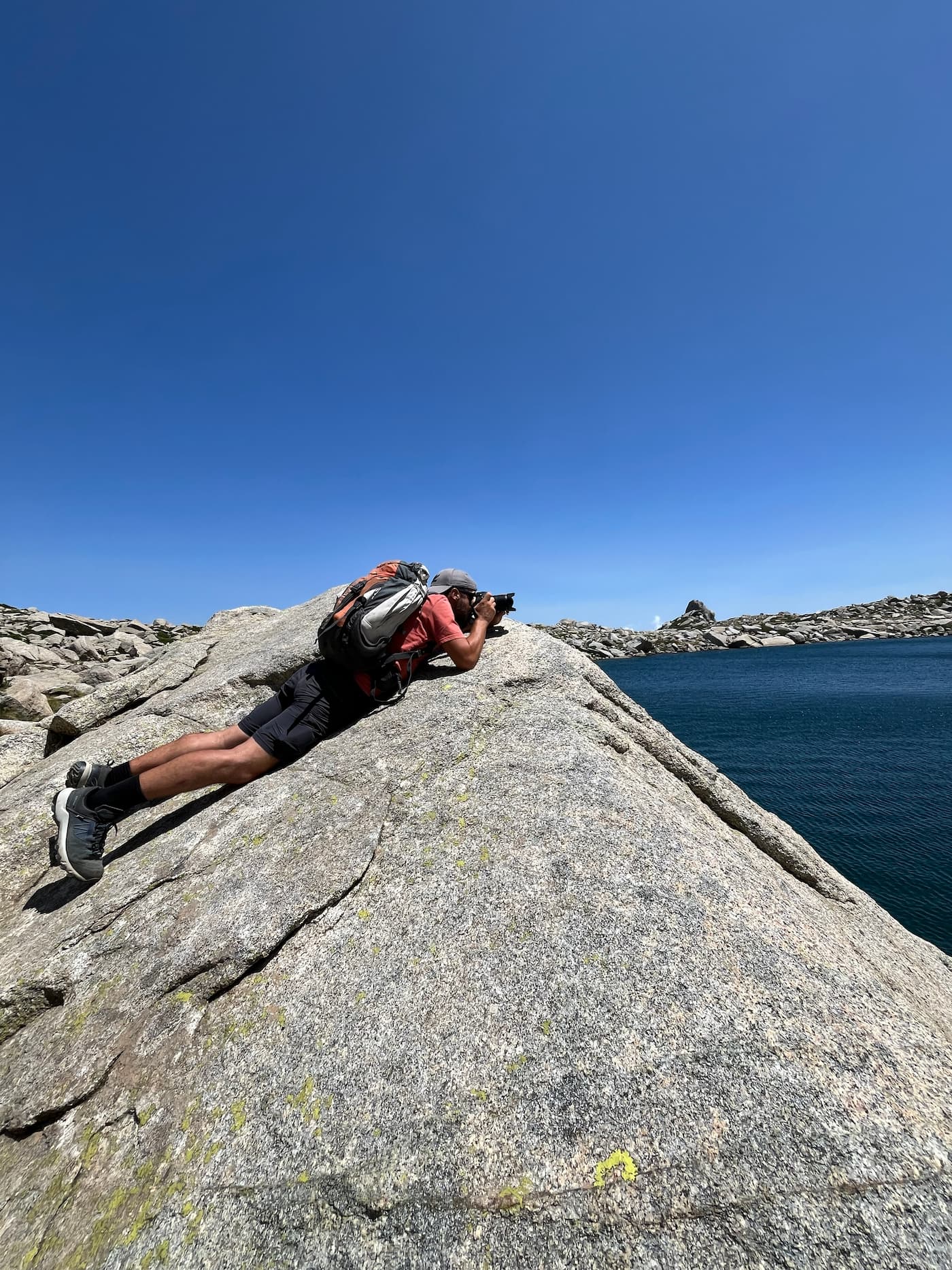 Photographe prenant une photo depuis un rocher en montagne