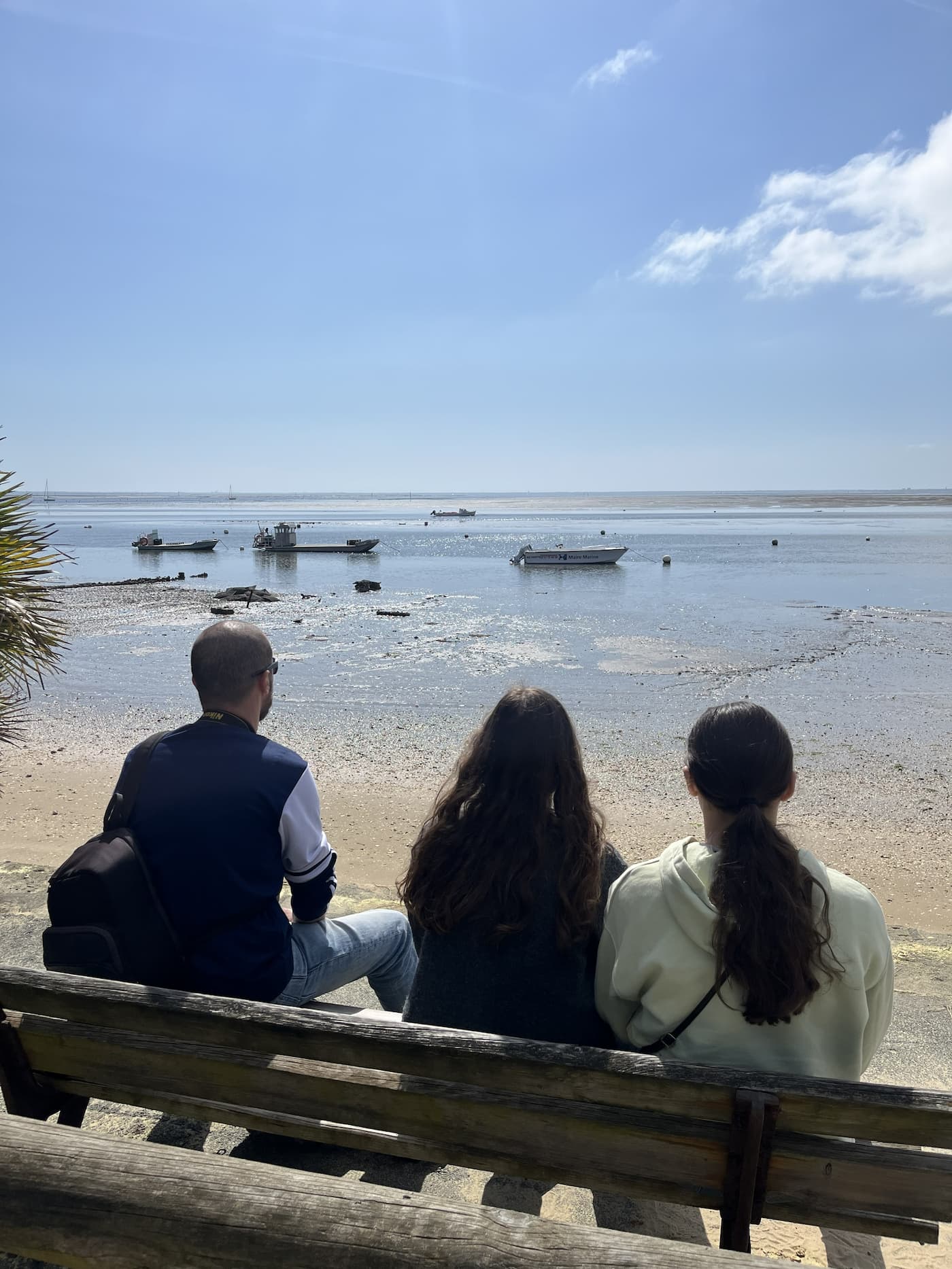 Trois personnes sur un banc face à la mer